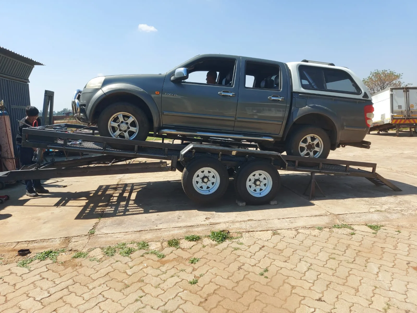 Vehicle loaded on a fabricated trailer